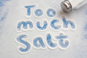 An image with the words "too much salt" drawn in a spilled pile of salt on a blue surface
