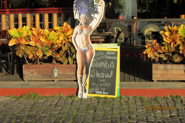 A poster advertising a samba show featuring a black woman in Carnival garb