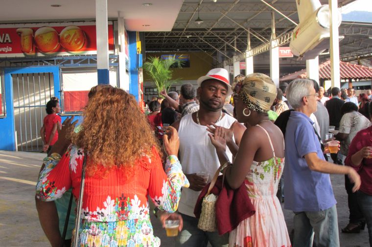 Black men talk to Brazilian women at May 13 celebration.