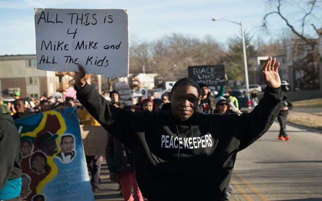 Demonstrators remember Michael Brown with a Martin Luther King Jr. Day march from the apartment complex where he was killed to the Ferguson police station on January 19, 2015 in Ferguson, Missouri. Brown, an unarmed black teenager, was shot and killed by Darren Wilson, a white Ferguson police officer August 9, 2014. His death caused months of sometimes violent protests in the St. Louis area and sparked nationwide outcry against use of excessive force by police. (Photo by Scott Olson/Getty Images)