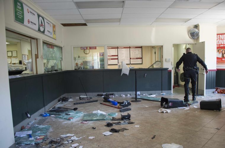 A security officer walks through a looted check cashing store in Baltimore.