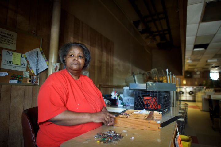 A worker from the local laundromat sits in the store following the riots in Baltimore.