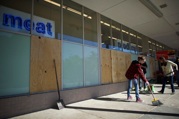 People take part in cleaning up the wrecked buildings in Baltimore.