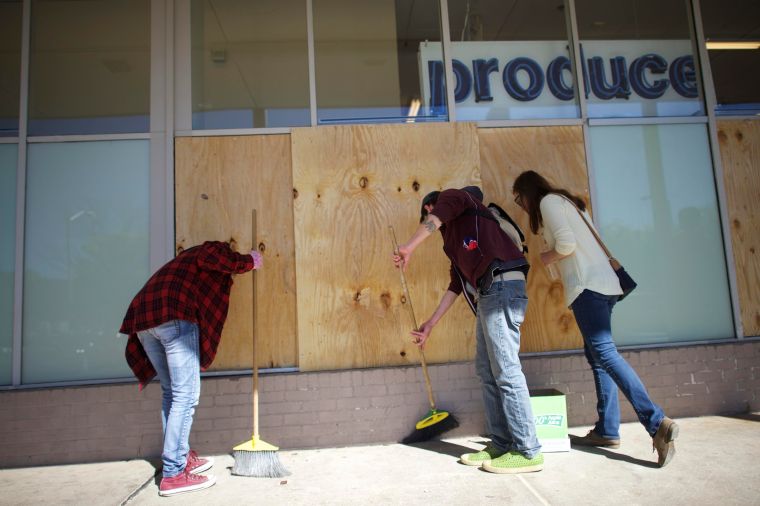 More volunteers help clean a looted mall lot in Baltimore.