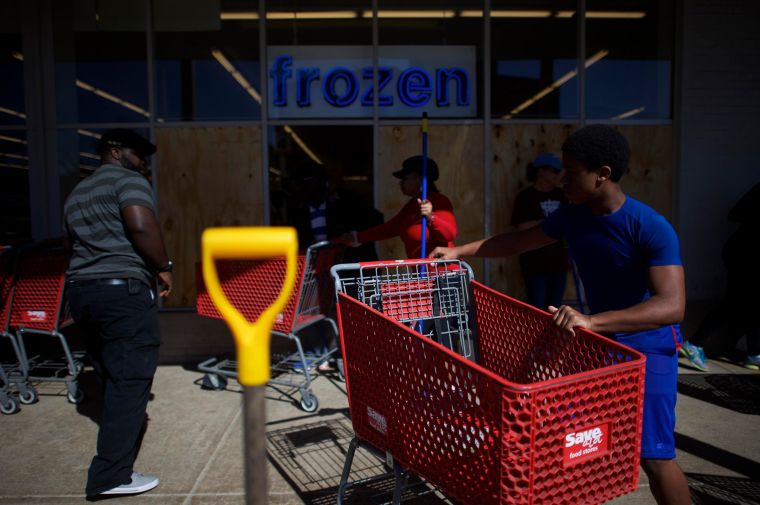Friends and pedestrians help clean up a looted store in Baltimore.