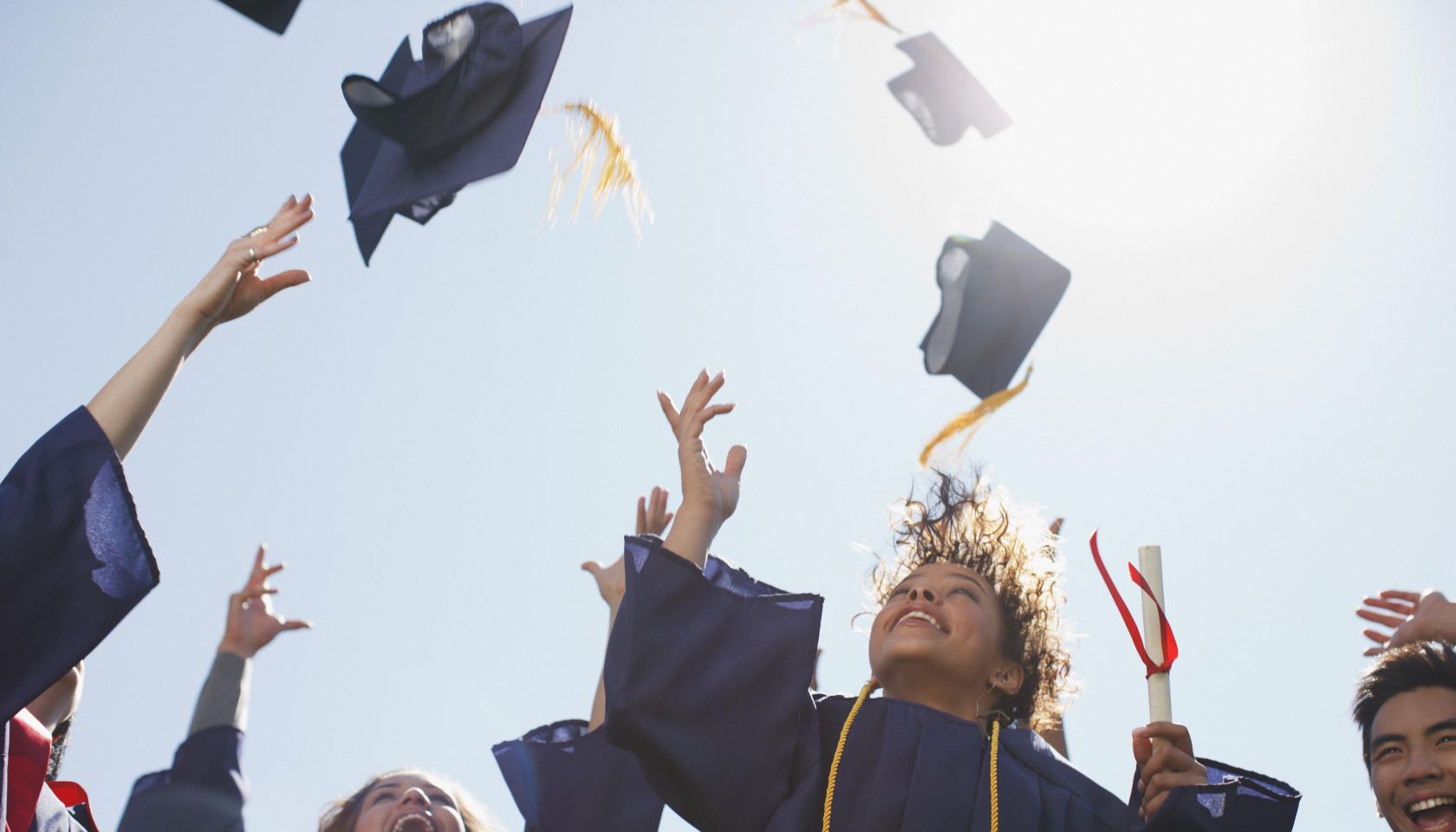Graduates tossing caps into the air