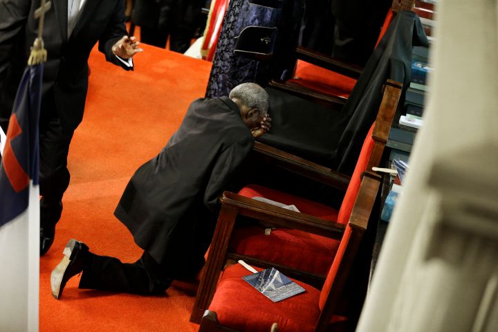 A parishioner prays at the empty seat of the Rev. Clementa Pinckney at the Emanuel AME Church.
