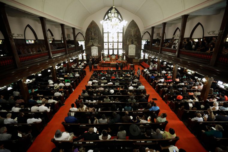 Parishioners sit at Emanuel AME Church four days after a mass shooting that claimed the lives of its pastor and eight others.