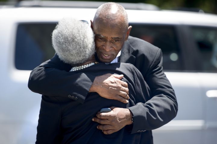 People embrace as they depart the Emanuel AME Church following Sunday services.
