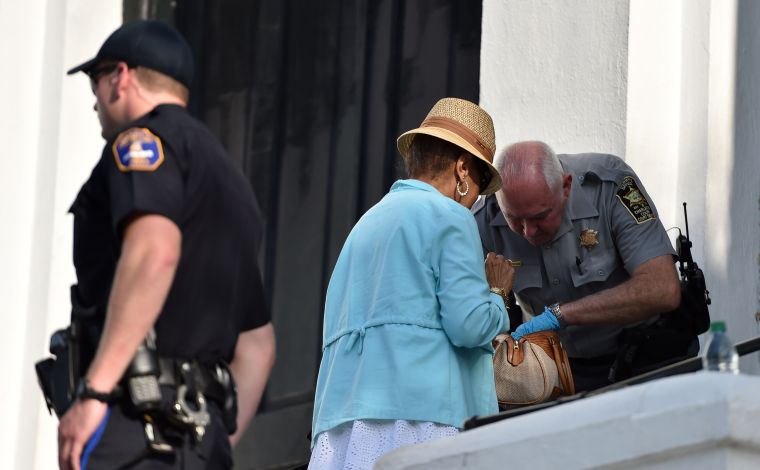 A Charleston County sheriff's deputy checks bags as people line up to enter for Sunday service at the Emanuel AME Church.