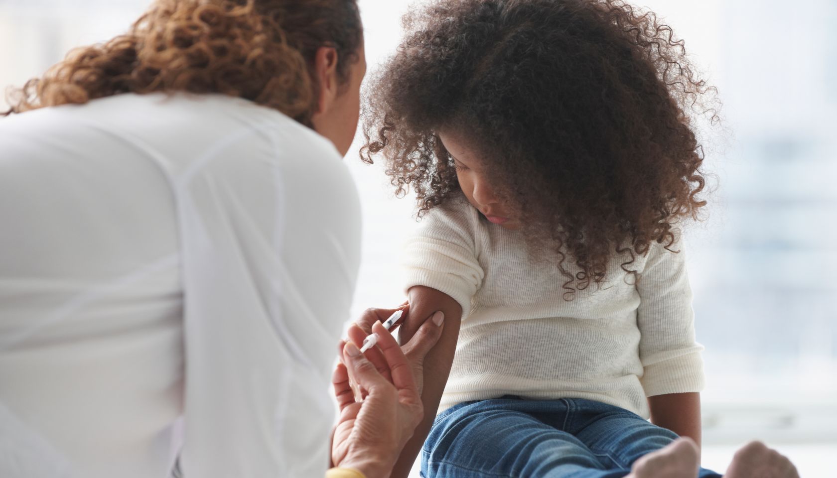 Doctor vaccinating girl in office