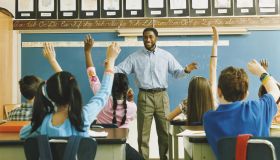 Teacher Standing in Front of a Class of Raised Hands