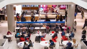 People at a food court inside a mall, with some people...