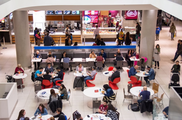 People at a food court inside a mall, with some people...