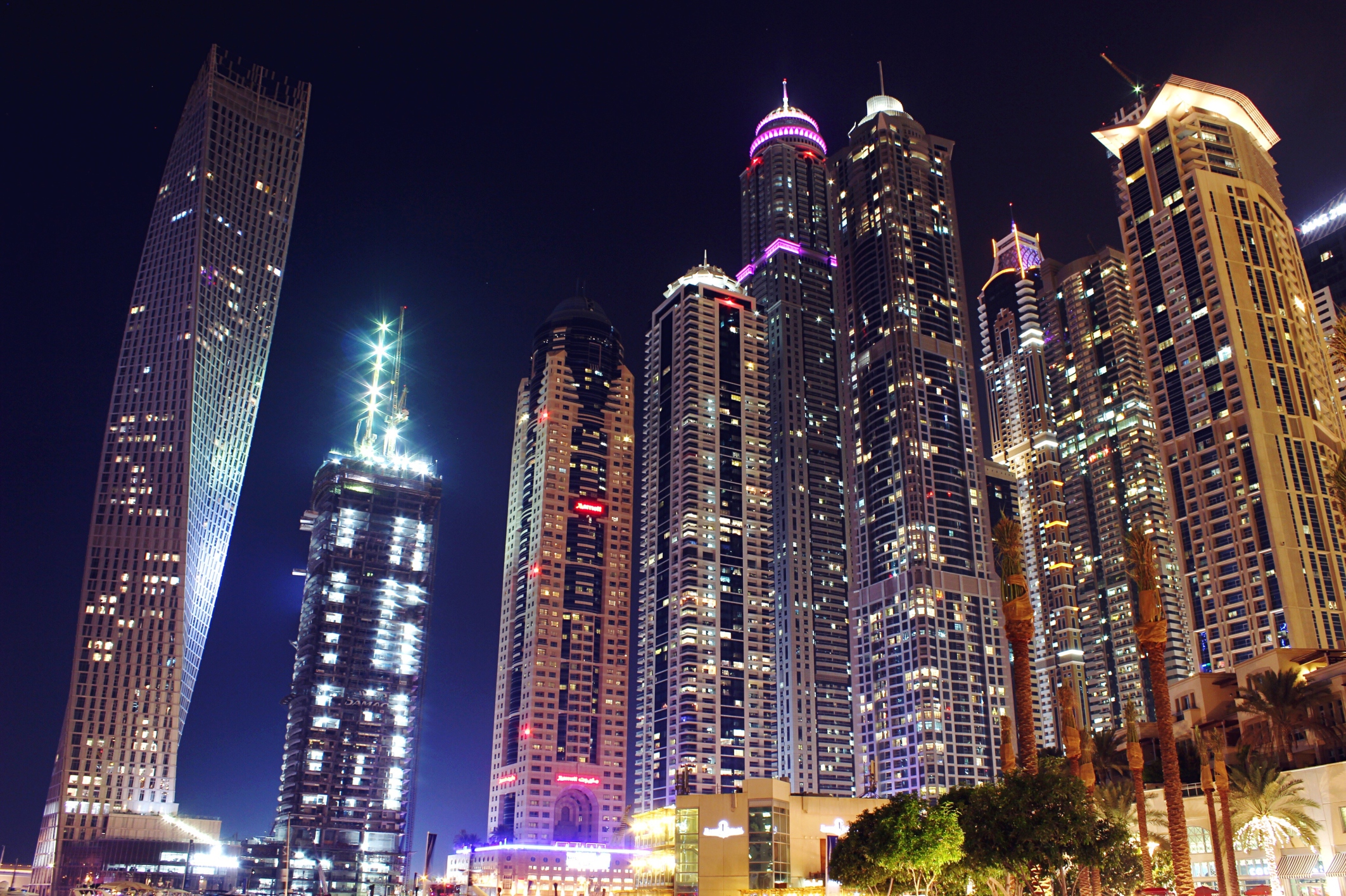 Low Angle View Of Illuminated Modern Skyscrapers At Dubai Marina During Night