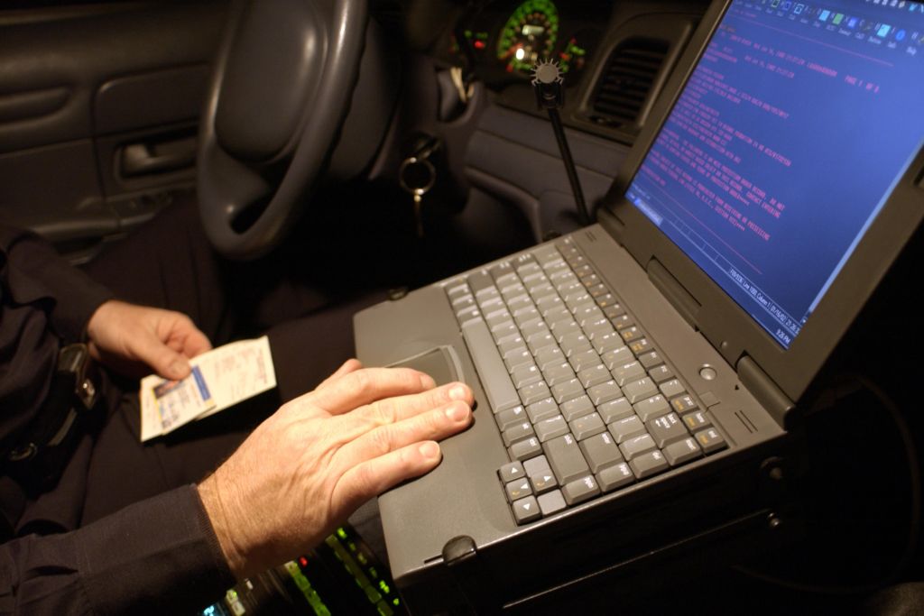 Police officer using computer in car