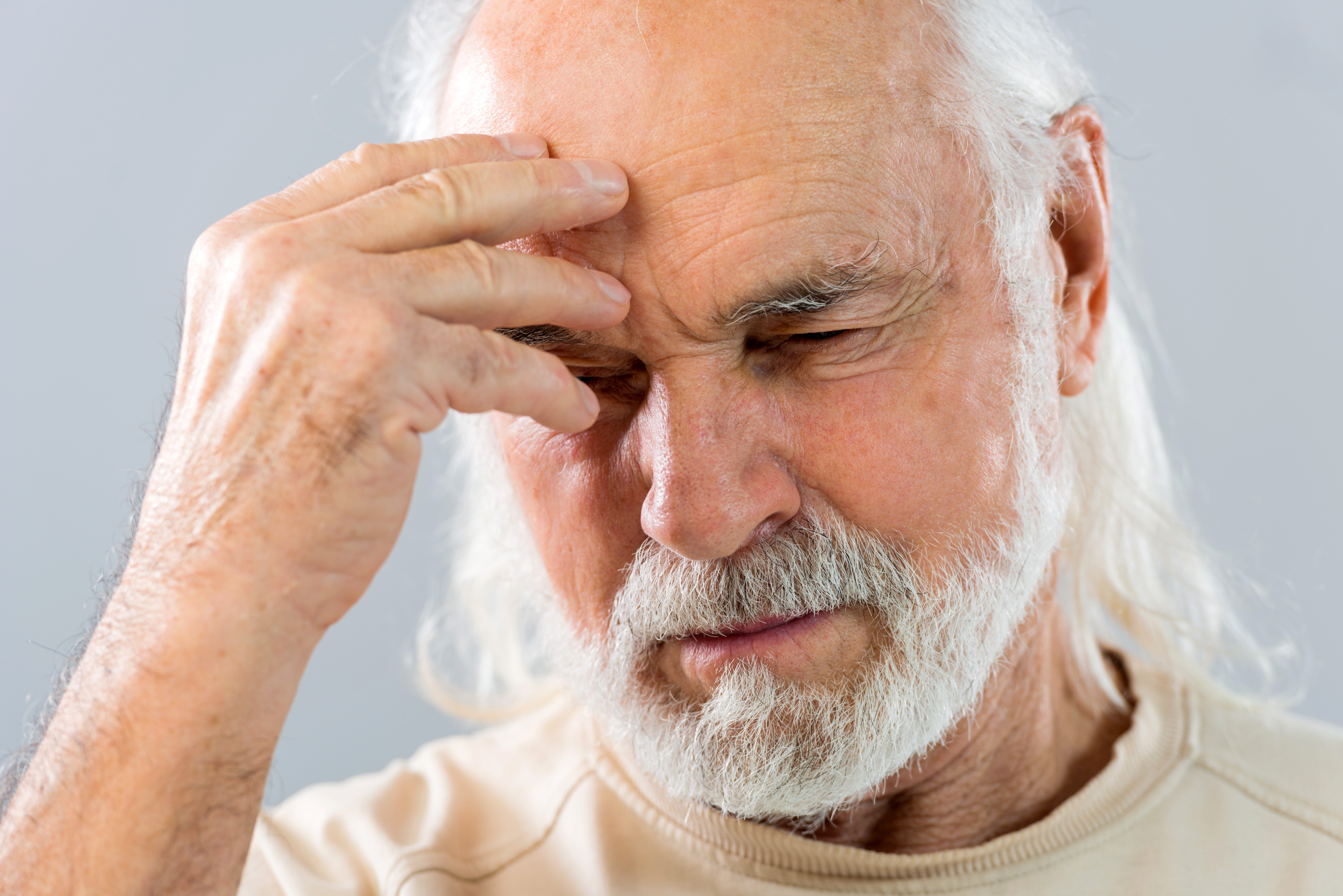 Senior man holding his head in pain.