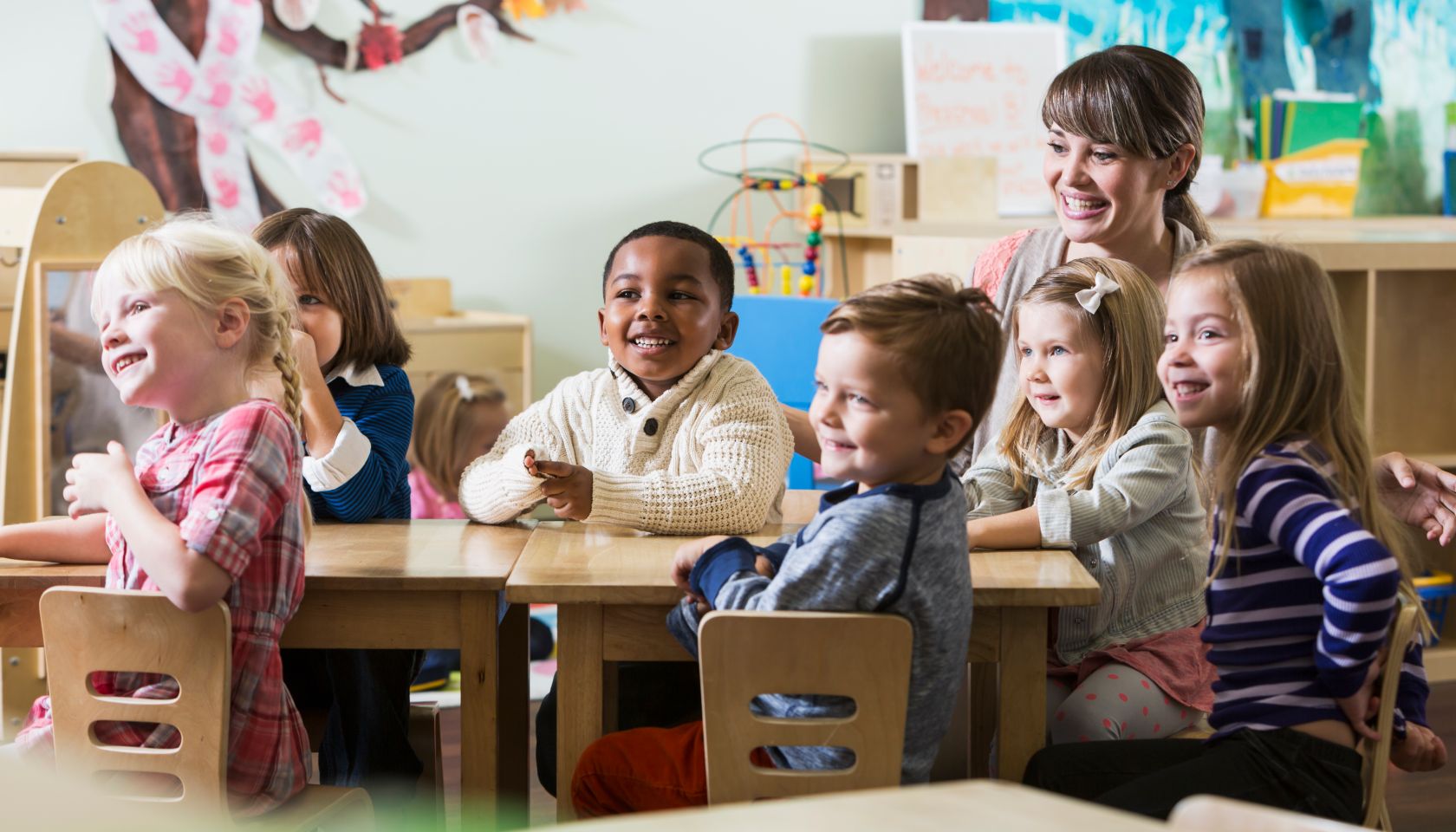 Teacher with group of preschoolers sitting at table