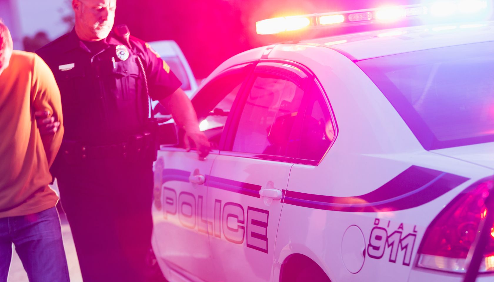 Police officer arresting a young man at night