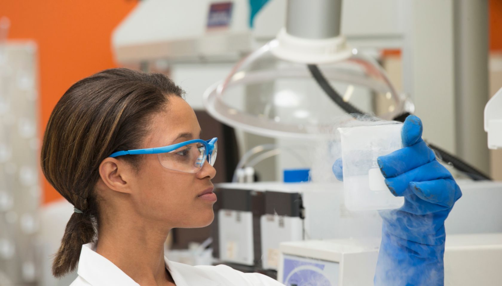 Black scientist examining liquid in laboratory
