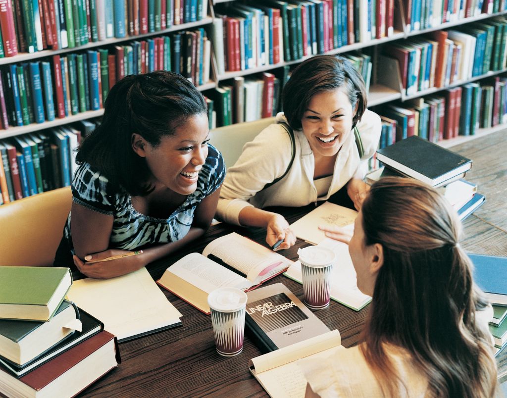 Three Female Students Talking in a Library