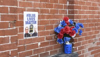 Blue Lives Matter poster on brick wall at site where...