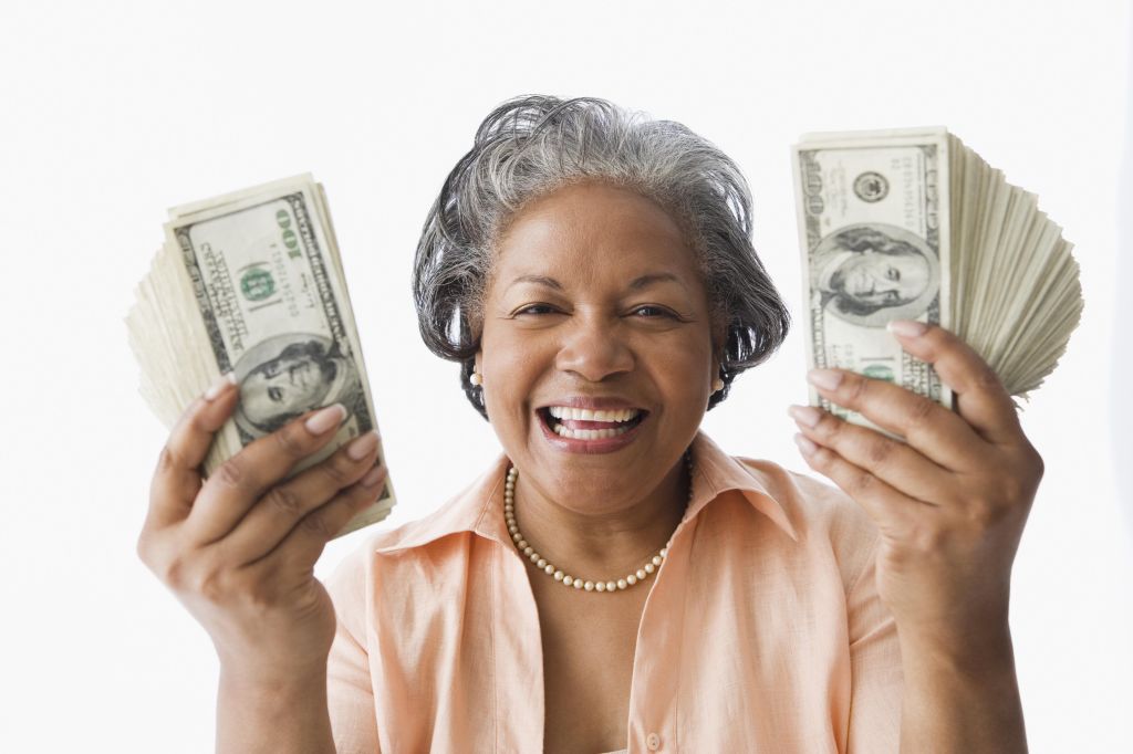 Portrait of senior African woman holding money