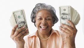 Portrait of senior African woman holding money