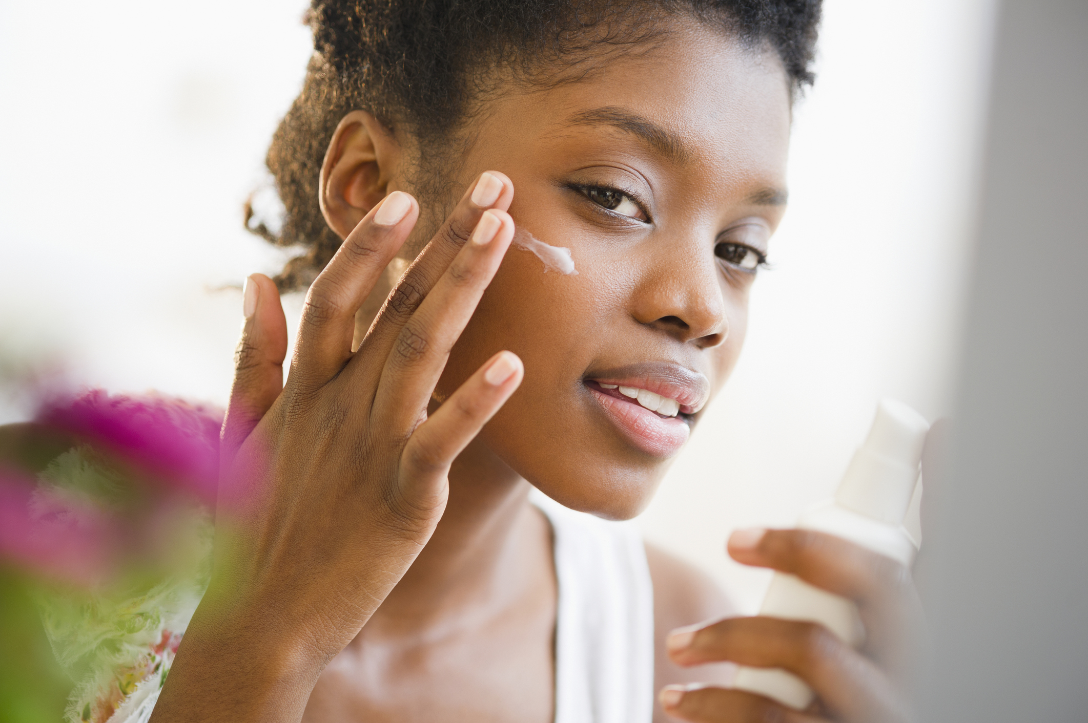 Black woman putting on face lotion, sunscreen, sun, Melanin, Skin Cancer, Melanoma, dark UV, Rays 