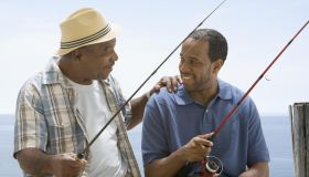 Father clasping son's shoulder while fishing