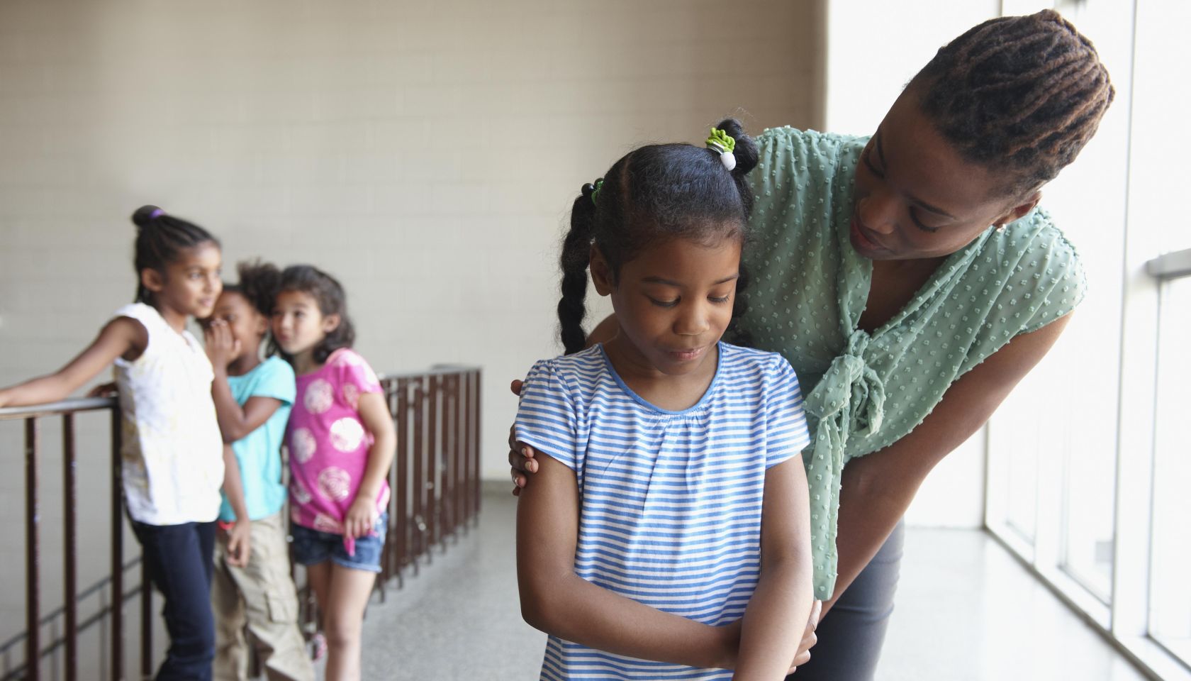 Teacher talking to bullied young girl