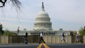 Pedestrians walk past the US Capitol and