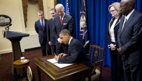 US President Barack Obama (C) signs a di