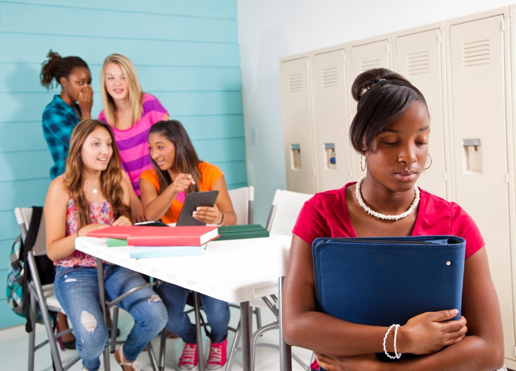 Teenage girls cyber-bully classmate using wireless technology.