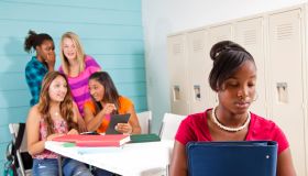Teenage girls cyber-bully classmate using wireless technology.