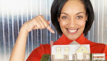 Woman Pointing to Model Home for Sale