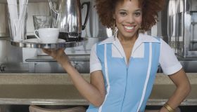 Waitress carrying tray of coffee and cup
