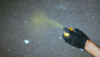 Cropped Hand Of Person Spraying On Street