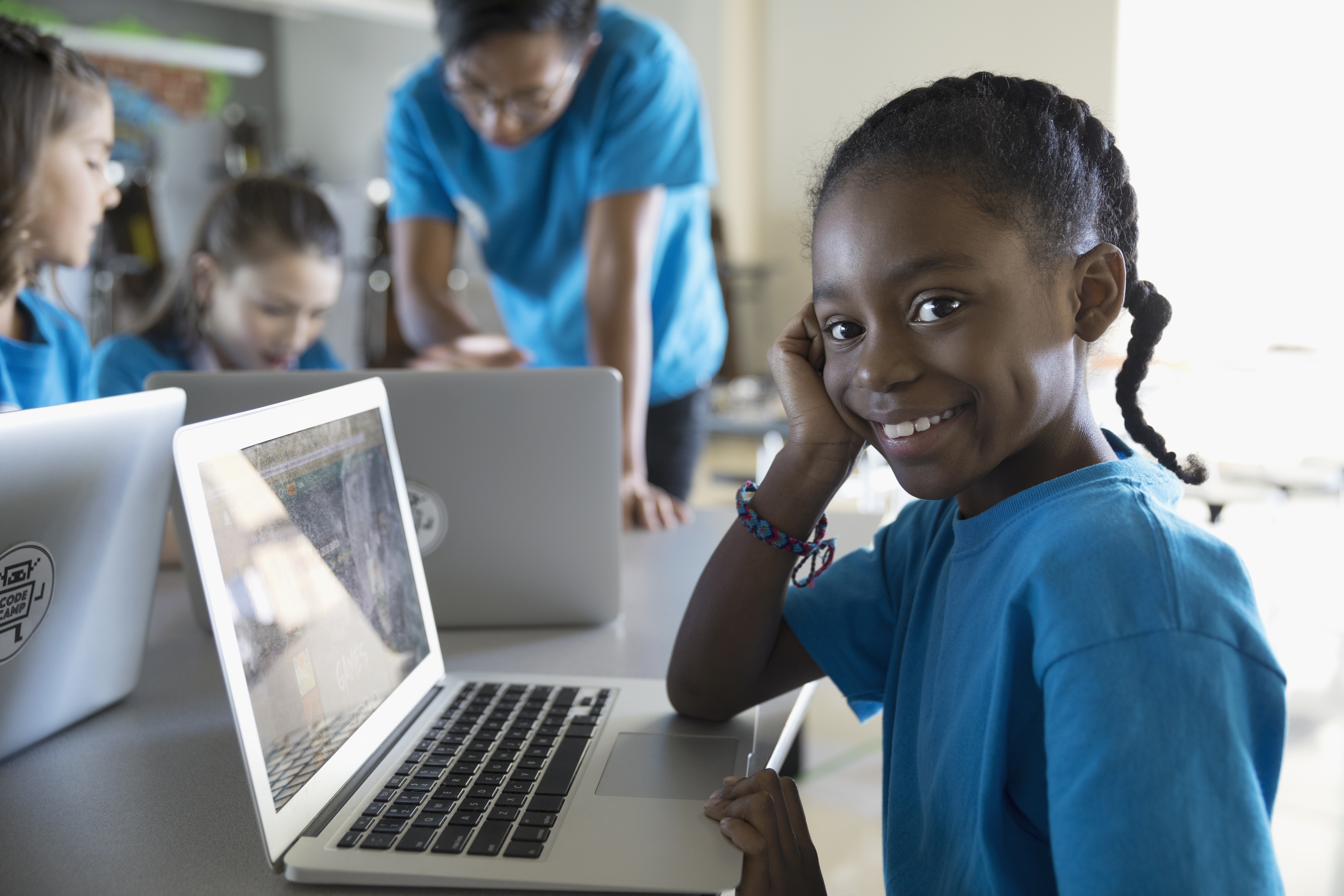 Portrait confident, smiling pre-adolescent girl using laptop in classroom
