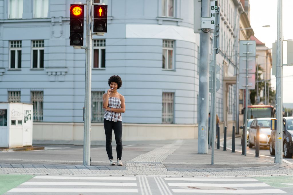 Teen girl waiting to crosswalk street at zebra crossing