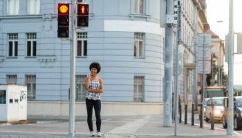 Teen girl waiting to crosswalk street at zebra crossing