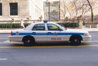 USA, Illinois, Chicago, police car driving along street, side view.