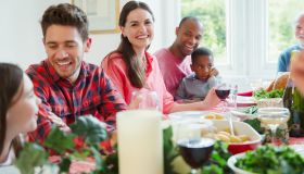 Portrait smiling woman enjoying Christmas dinner with family at table