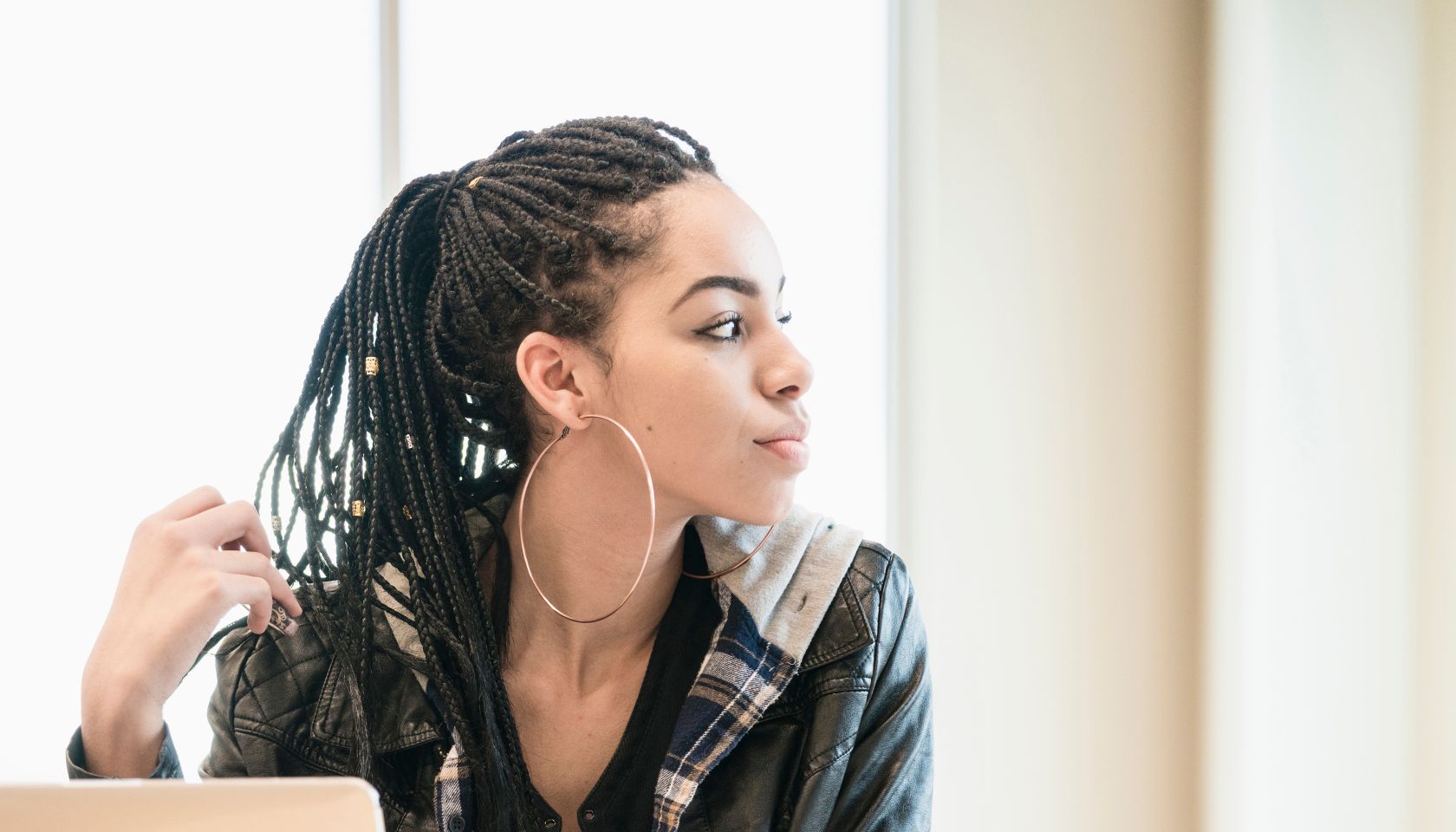Black teenage girl looking away from laptop