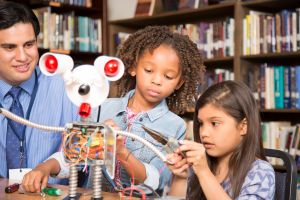Elementary age school girls build robot in technology class.