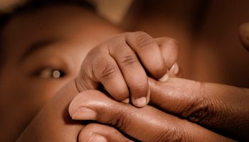 Infant Holding Adult's Fingers