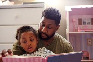 Father reading to daughter