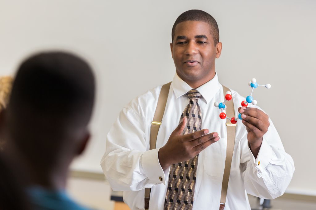 Confident high school science teacher teaches about molecular structure