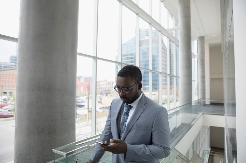 Businessman texting with cell phone in office