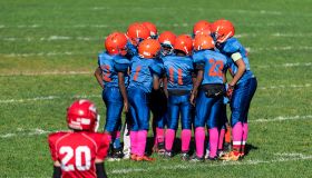 Young boys in the huddle during a Pop Warner football game...